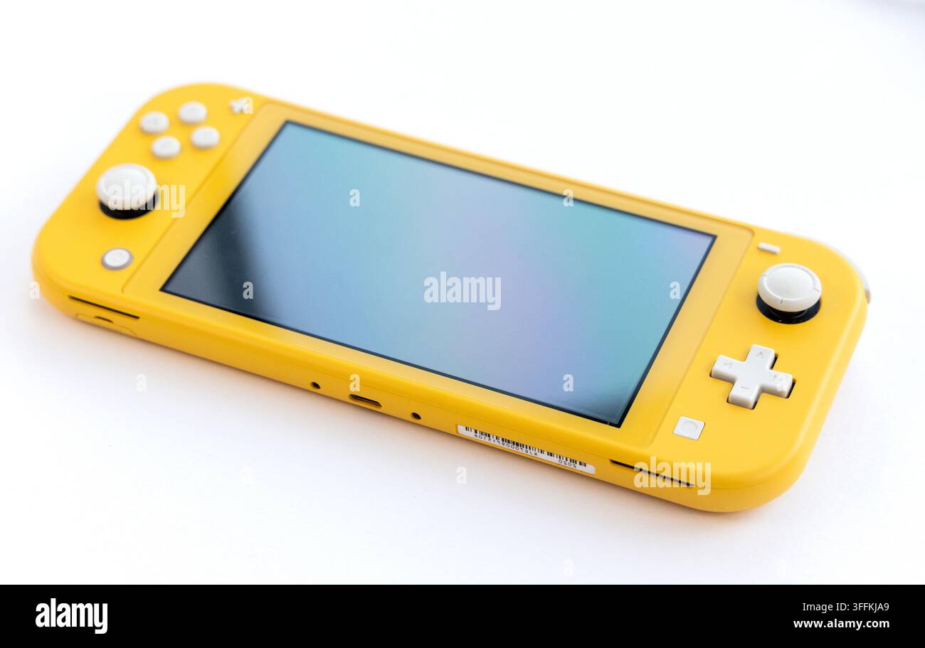 Eine hellgelbe Handheld-Spielekonsole ruht auf einem weißen Hintergrund Stockfoto