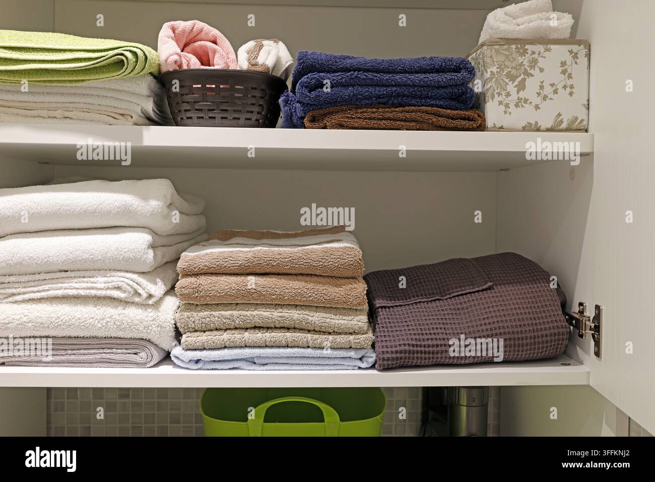 Ästhetische Haushaltsspeicherorganisation mit ordentlich gefalteten Badehandtüchern. Stockfoto