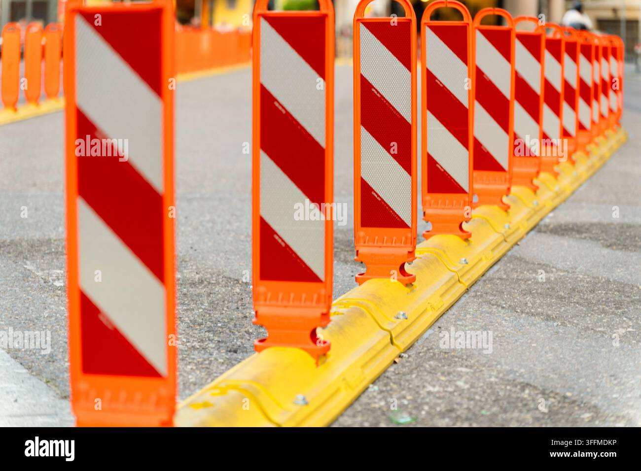 Anti-Park-Bollard in der Stadt. Reihe von Barrieren auf der Straße, die Verkehrszonen trennt. Zebrastreifen für Fußgänger. Zebrastreifen-Bollard. Verkehrstrennungsmarkierung Stockfoto