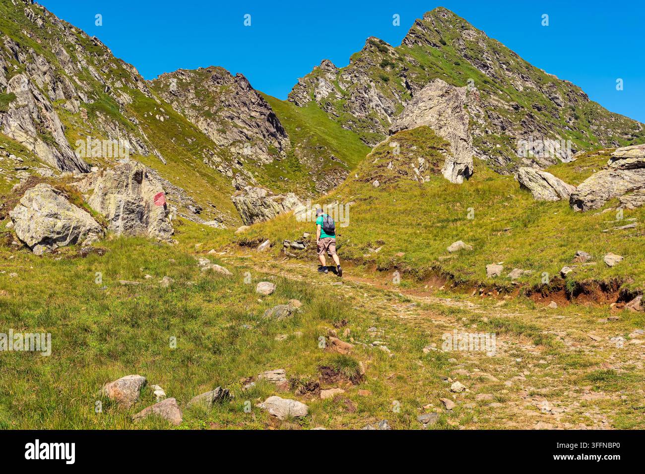 Einsamer Wanderer geht auf einem felsigen Pfad in den Karpaten in der Transsilvanien, Rumänien Stockfoto
