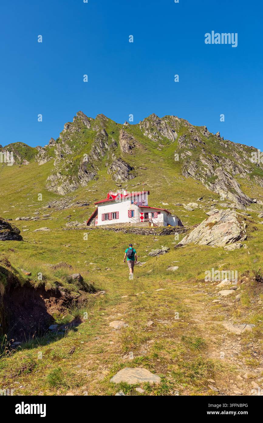 Wanderer nähert sich einer Berghütte in den Karpaten Transsilvaniens, Rumänien Stockfoto