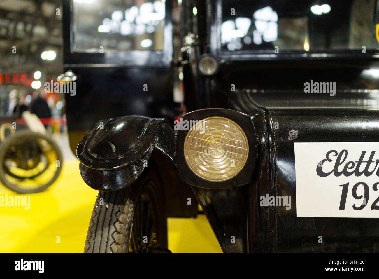 Mailand, Italien - 12.11.2022: Vintage-Scheinwerfer und Rad einer schwarzen Limousine im Nahaufnahme bei einer Ausstellung. Ausstellung Milano Autoclassica Stockfoto