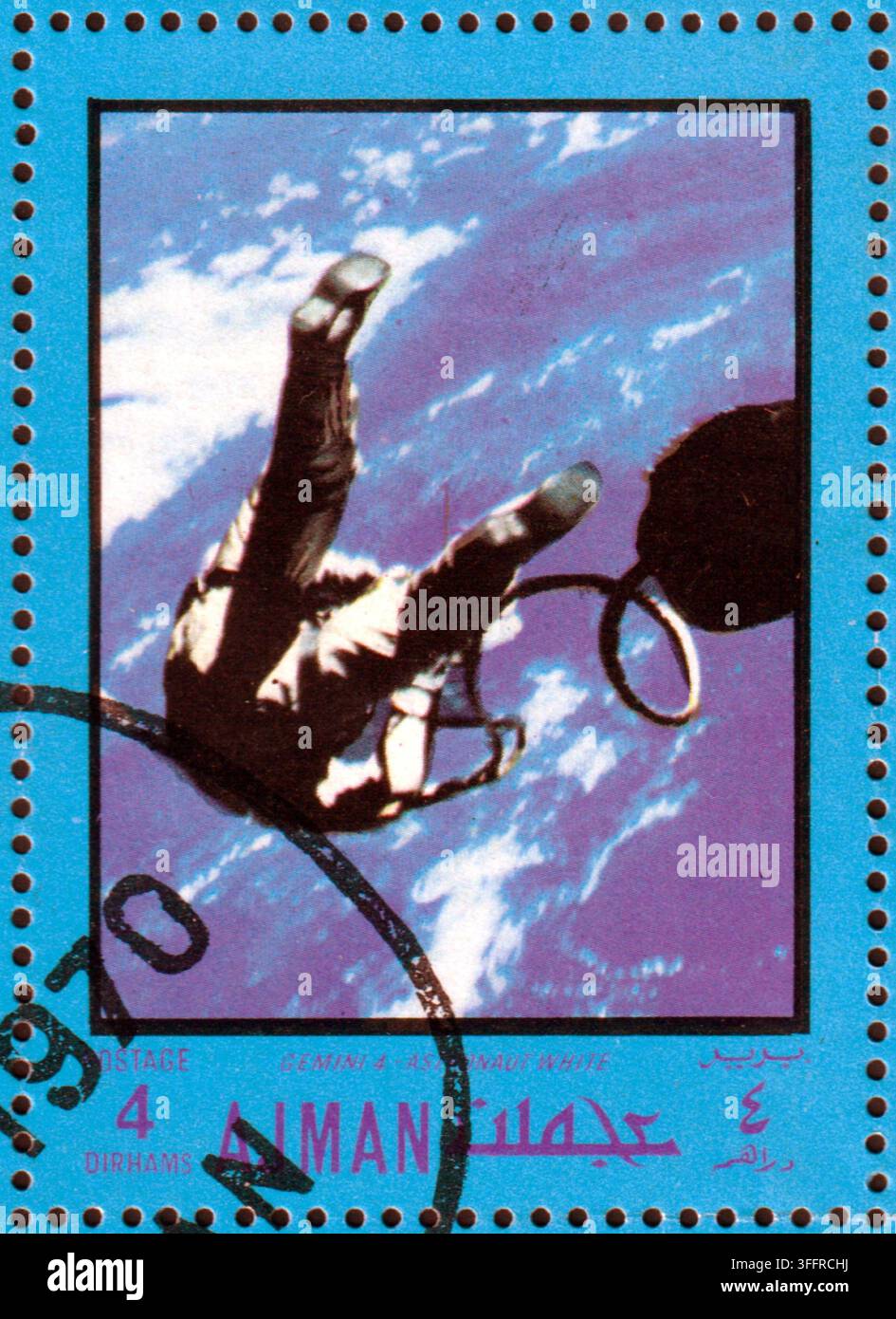 Eine vintage Briefmarke von 1970 aus Ajman mit der Saturn-5-Rakete auf ihrer massiven Startplattform bei Nacht, heller blauer Rand. Stockfoto