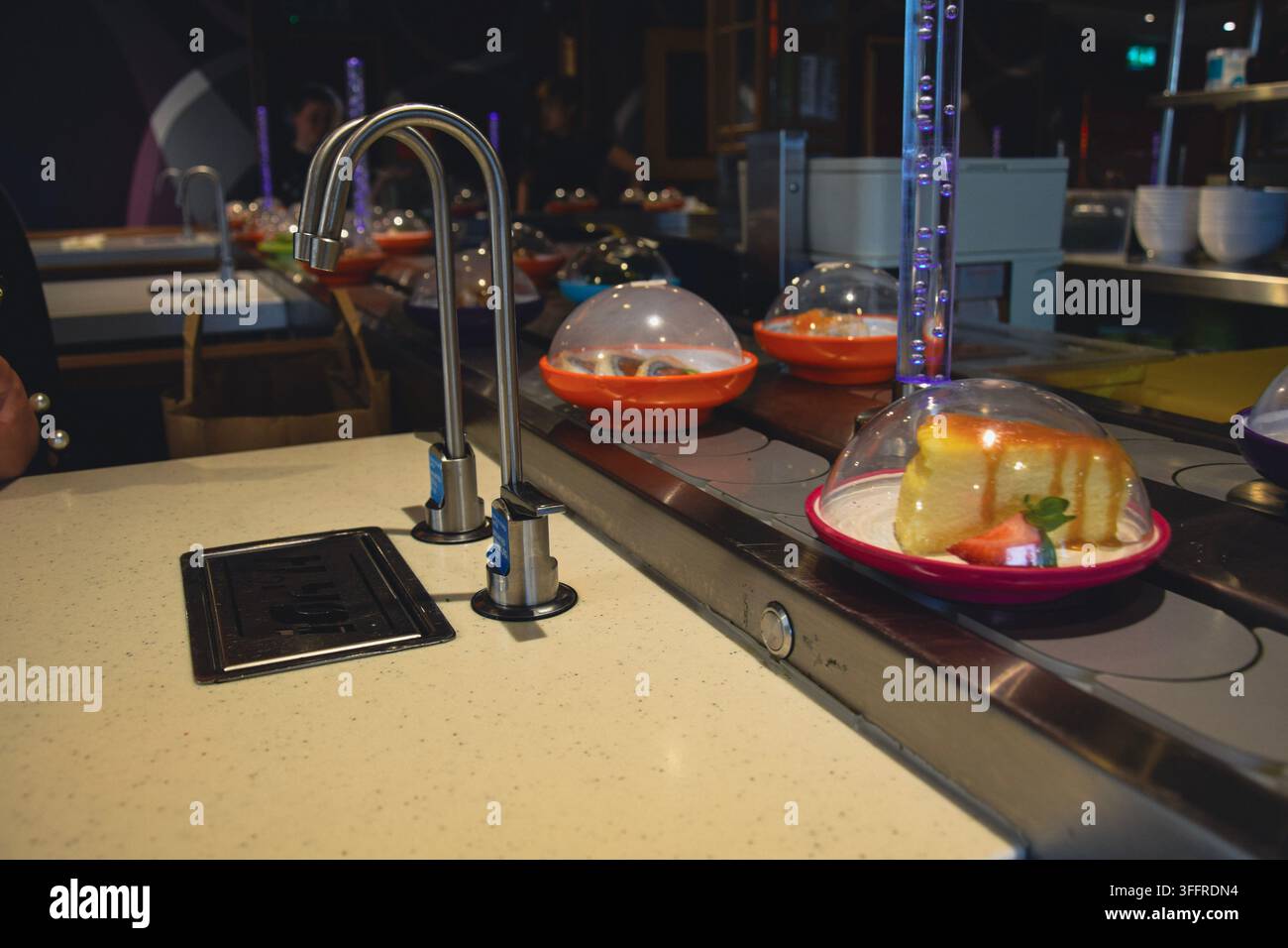 Sushi-Restaurant mit conveyor belt und verschiedenen Gerichten und Desserts Stockfoto