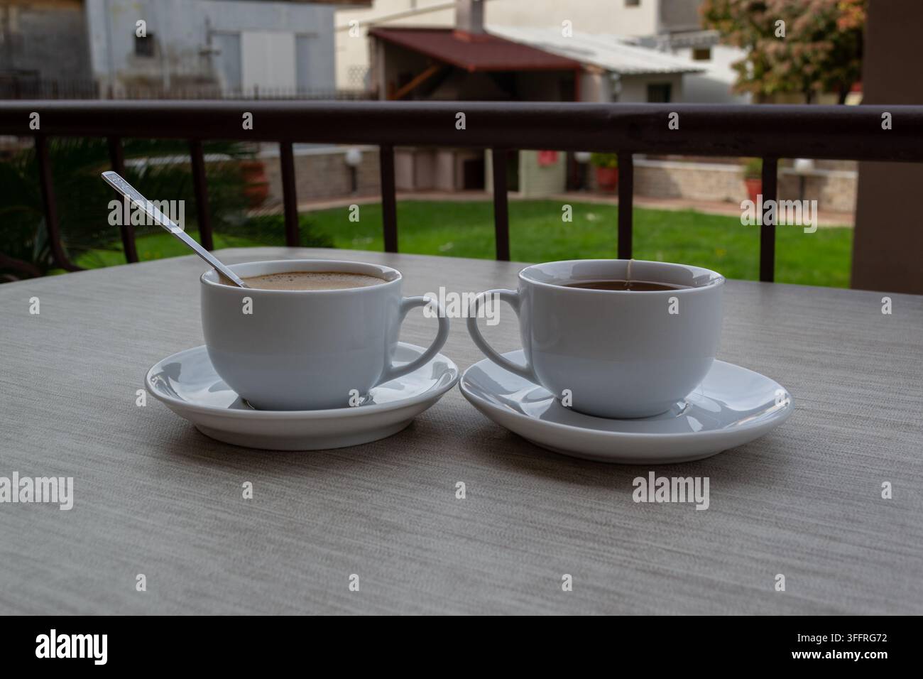 Zwei Tassen Kaffee und Tee auf einem Außentisch Stockfoto