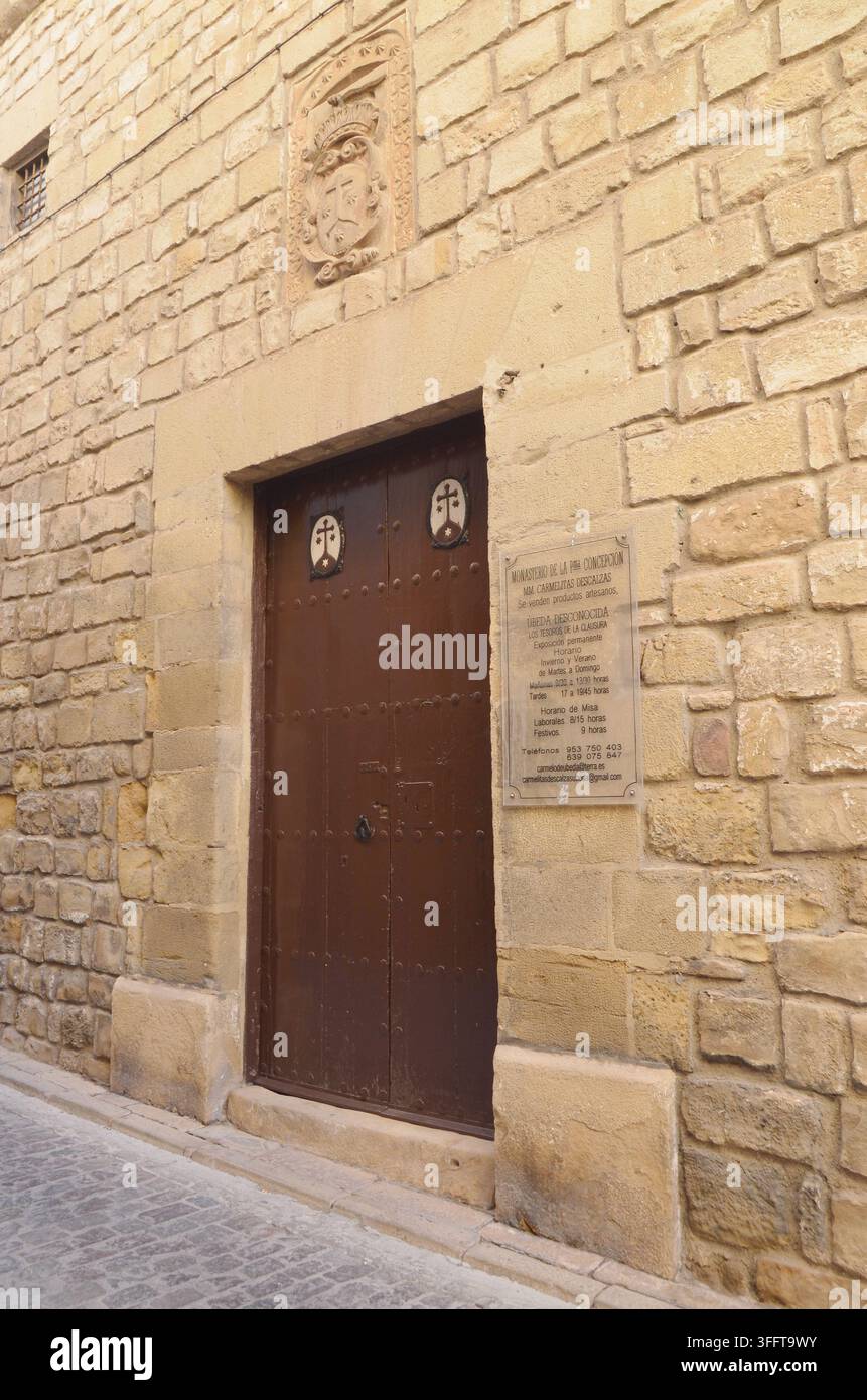 Ashlar-Stein-Fassade mit Sturzportal, Wappenschild und Karmeliter-Emblemen im Kloster der Unbefleckten Empfängnis in der Stadt Úbeda. Stockfoto