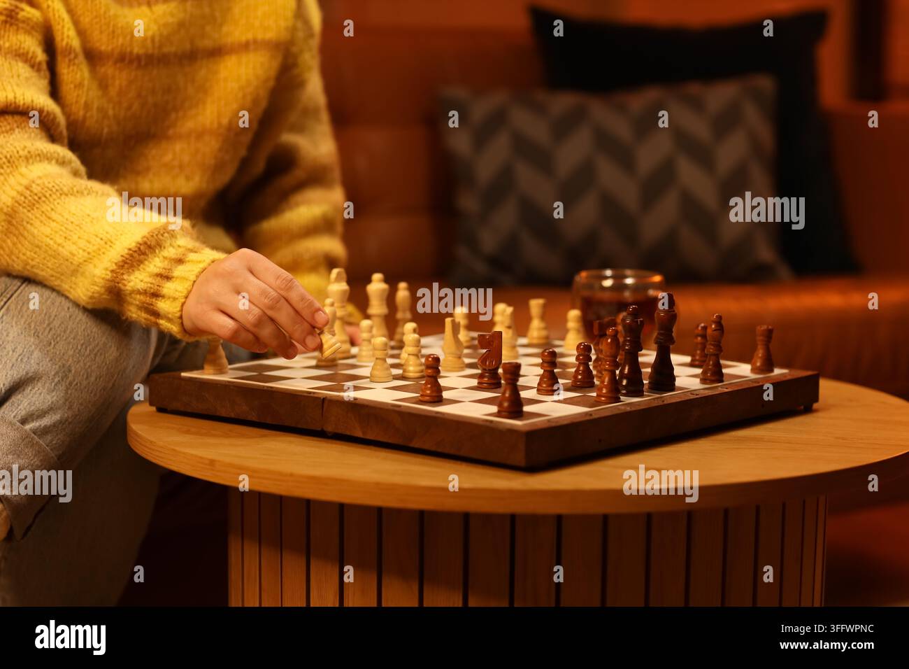Strategisches Denken und Entscheidungsfindung, Person spielt Schach zu Hause für mentale Herausforderung und Freizeitaktivität in einer gemütlichen Wohnraumumgebung Stockfoto