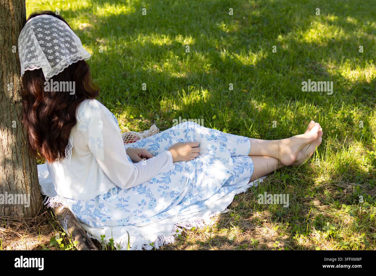 Junge Frau ruht in der Natur und genießt einen ruhigen Sommermoment Stockfoto