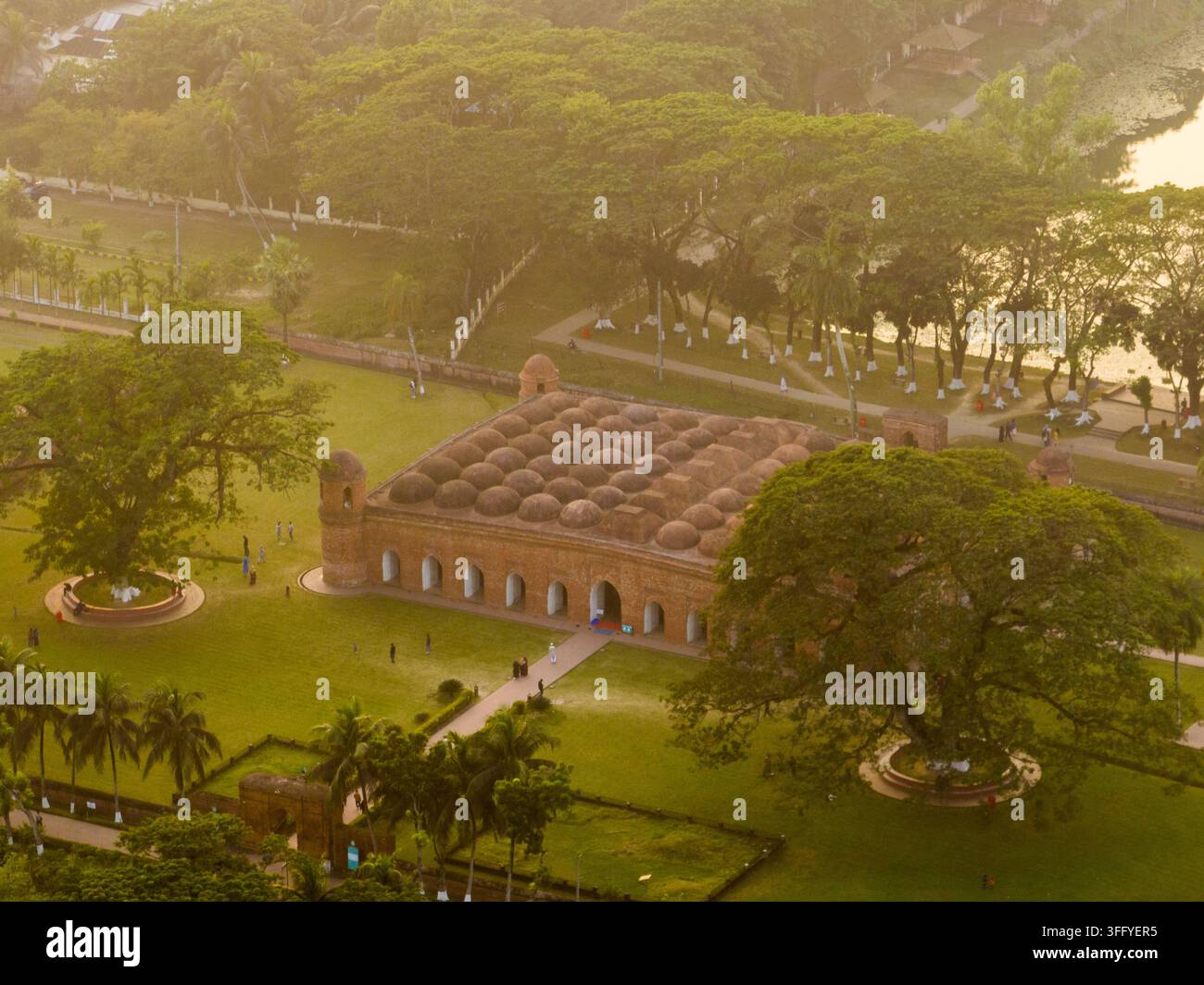 Luftaufnahme der historischen Sixty Dome Mosque mit ihren zahlreichen Terracotta-Kuppeln, umgeben von üppigen grünen Rasenflächen und großen Bäumen in Bagerhat, Khulna Di Stockfoto