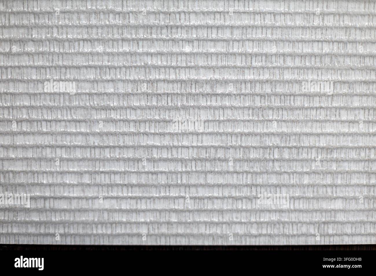 Weiße gerippte Oberfläche mit sich wiederholender horizontaler Textur. Nahaufnahme einer weißen strukturierten Oberfläche mit sich wiederholenden horizontalen Rillen und feinen vertikalen Linien Stockfoto