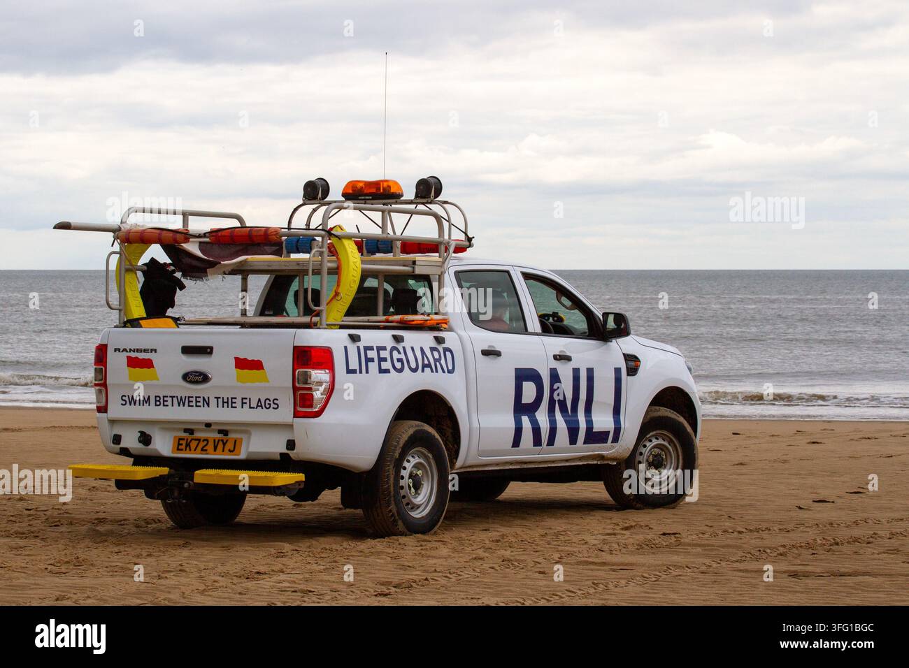 Ein weißer Ford Ranger-Lebensrettungs-Patrouillenwagen der Royal National Lifeboat Institution (RNLI) auf einem Sandstrand geparkt. Southport, UK. Stockfoto