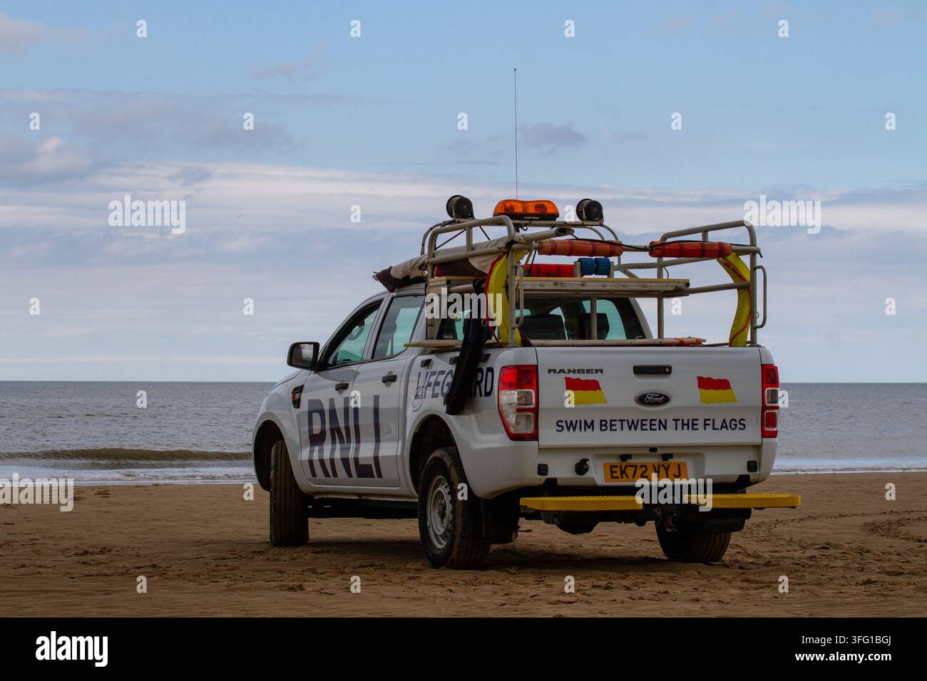 Ein weißer Ford Ranger-Lebensrettungs-Patrouillenwagen der Royal National Lifeboat Institution (RNLI) auf einem Sandstrand geparkt. Southport, UK. Stockfoto