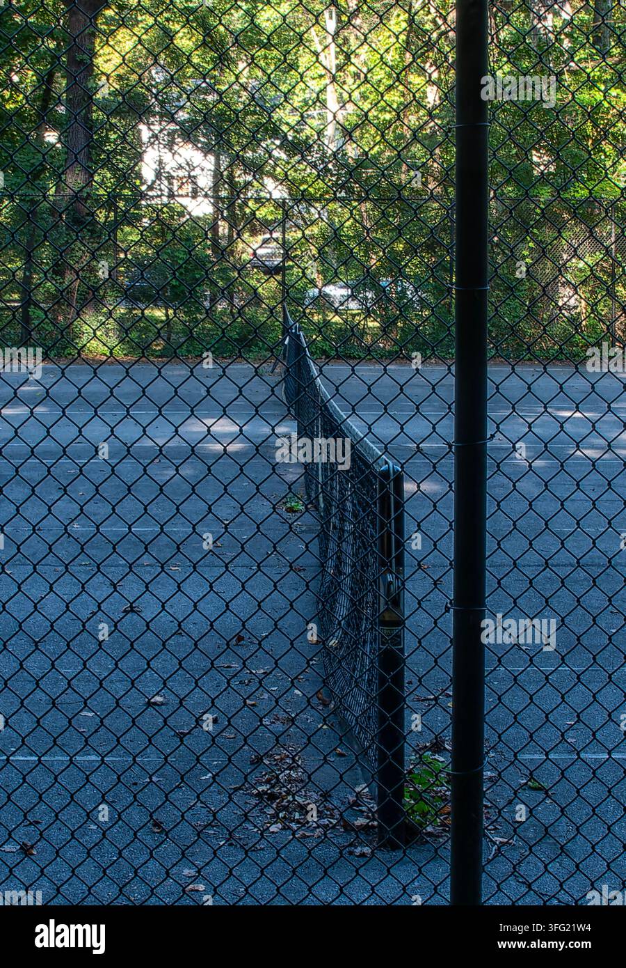 Ein Tennissnetz, das über einen Außen-Hartplatz gespannt ist. Stockfoto