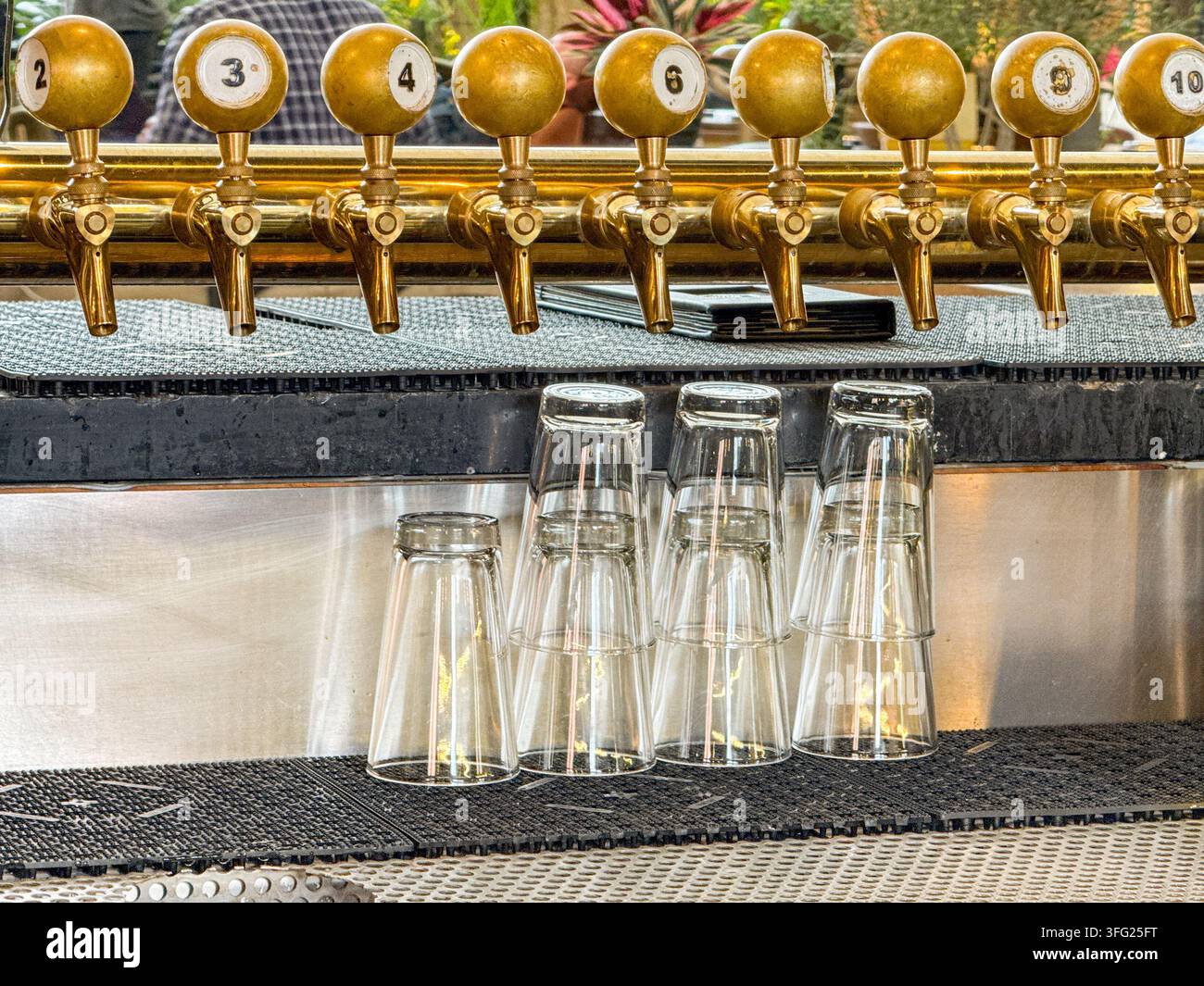 Leere Gläser unter einer Reihe von Zapfhähnen in einer Bar in den USA Stockfoto