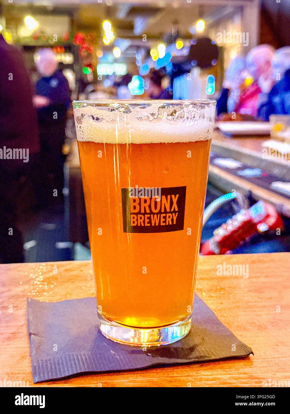 New York City, New York, USA - 9. Januar 2026: Pintglas mit goldenem Lagerbier der Bronx Brewery an einer Bar im Zentrum von Manhattan. - Smartphone-aufgenommenes Stockfoto