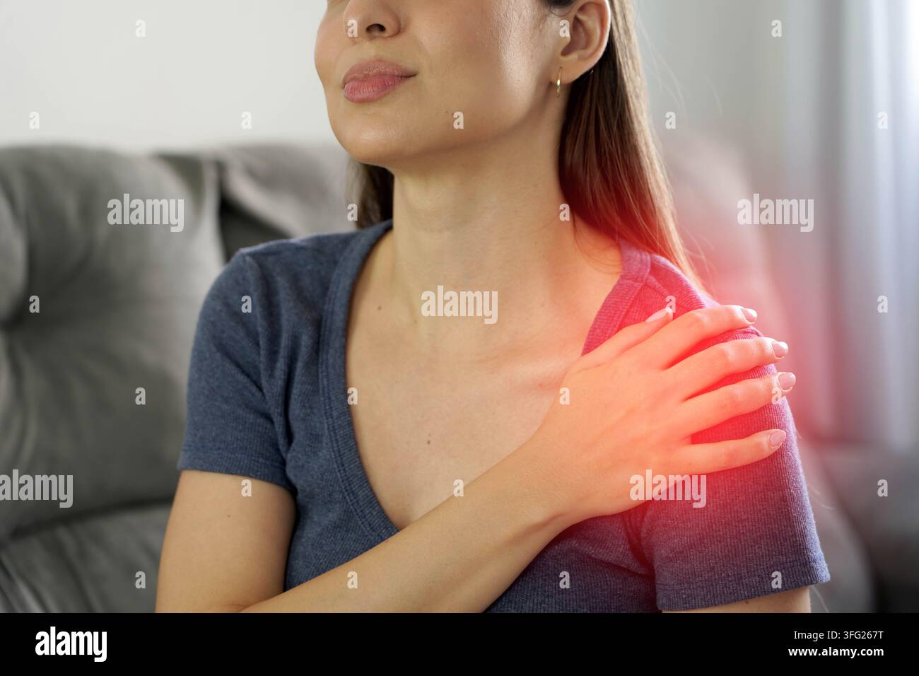 Periarthritis und Schultersteifung. Unerkennbare Frau hält ihre schmerzhafte Schulter. Der schmerzhafte Bereich ist rot markiert. Stockfoto