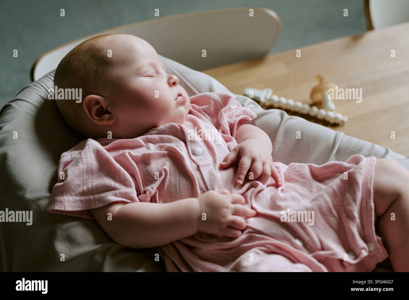 Baby-Mädchen schläft friedlich in einem Wippstuhl zu Hause Stockfoto