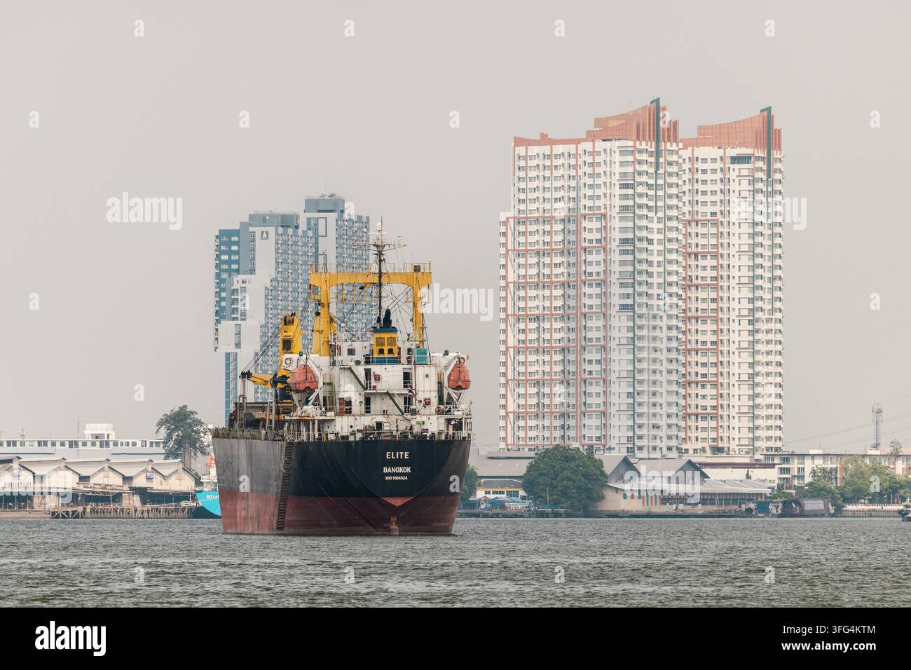 Frachtschiff passiert das Hochhaus-Wasserfront von Bangkok Stockfoto