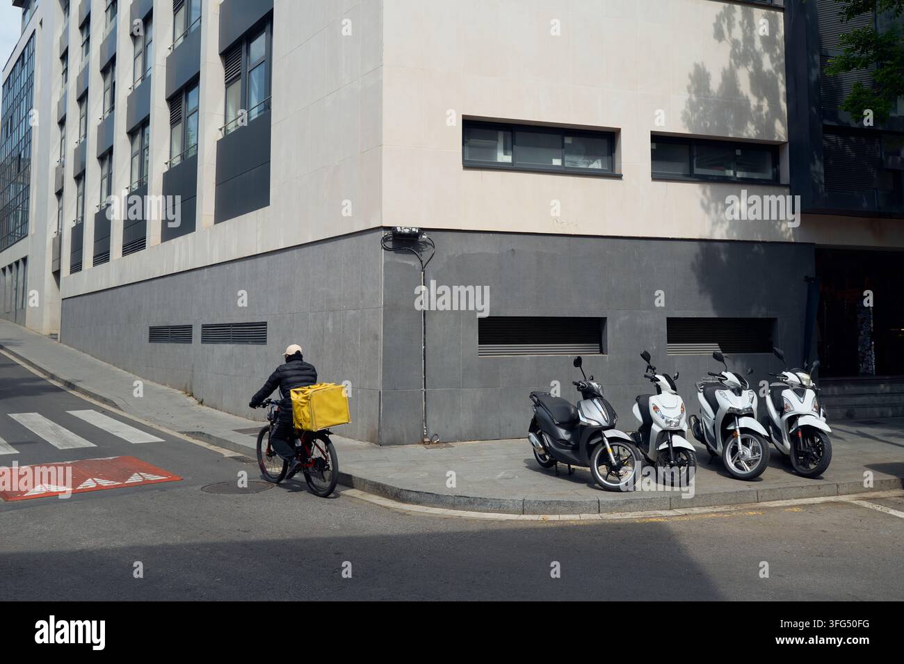 Lebensmittel-Lieferkuriere auf einem Fahrrad an einer Straßenecke der Stadt Stockfoto