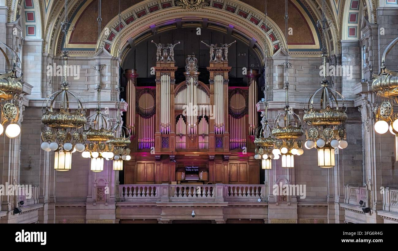 Die große Orgel der Kelvingrove Art Gallery and Museum in Glasgow steht beleuchtet unter kunstvollen, hängenden Kronleuchtern in der Haupthalle. Stockfoto