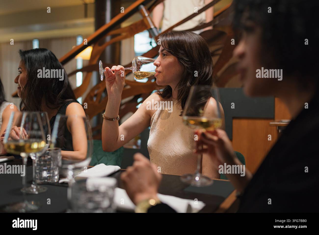 Gruppe von Freunden genießt Essen und Getränke im Restaurant, während sie während des Abendessens Geschichten und Gelächter teilen. Stockfoto