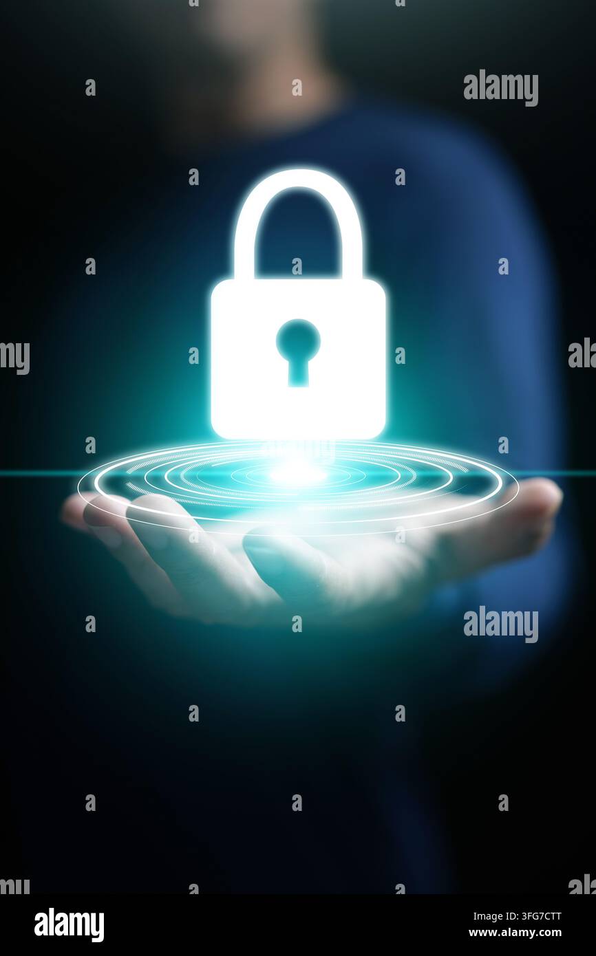 Cybersecurity-Konzept, eine Männerhand, die ein leuchtendes Schlosssymbol für System-, Daten- oder Netzwerkschutz, Sicherheit, Schutz und Privatsphäre auf vertikalem Dunkel hält Stockfoto