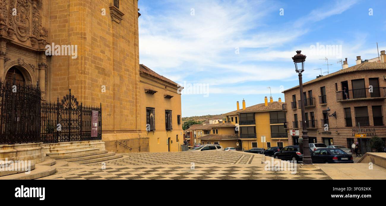 Seite der Kathedrale von Guadix neben einem städtischen Platz und umliegenden Gebäuden. Guadix, Provinz Granada, Andalusien, Spanien. - Smartphone-aufgenommenes Stockfoto