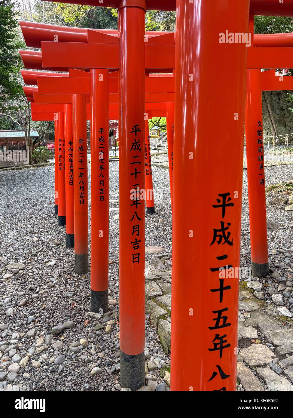 Nahaufnahme von roten Torii-Toren mit Kanji-Inschriften am Kuno-Inari-Schrein in Shizuoka, Japan. - Smartphone-aufgenommenes Stockfoto