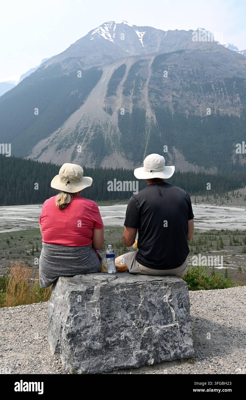 Ein Paar sitzt vor einer Bergkulisse. Reisen, Träume, Leben. Landschaft von Kanada mit Menschen. Jasper-Nationalpark, Alberta. Kanada. Stockfoto