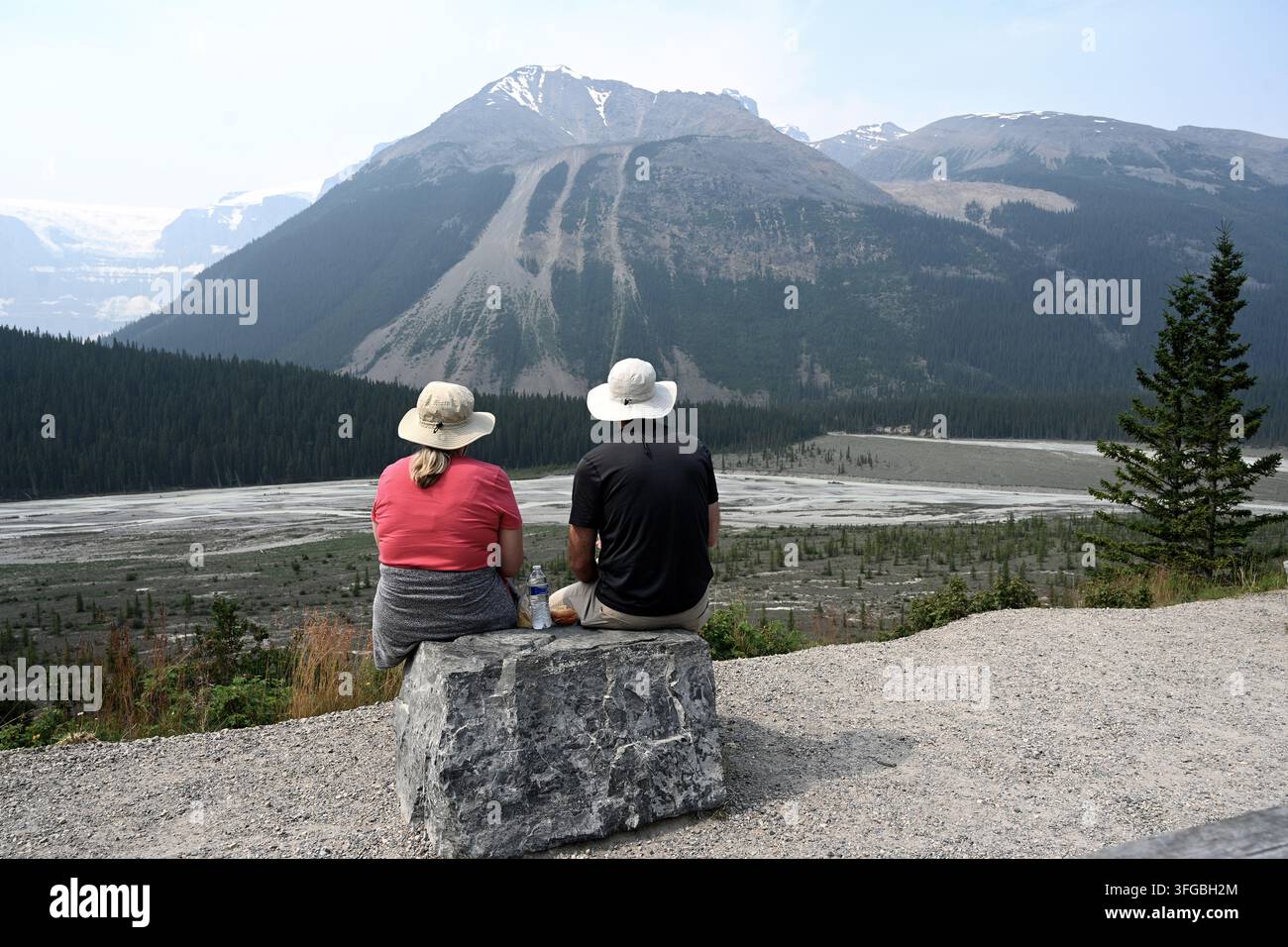 Ein Paar sitzt vor einer Bergkulisse. Reisen, Träume, Leben. Landschaft von Kanada mit Menschen. Jasper-Nationalpark, Alberta. Kanada. Stockfoto
