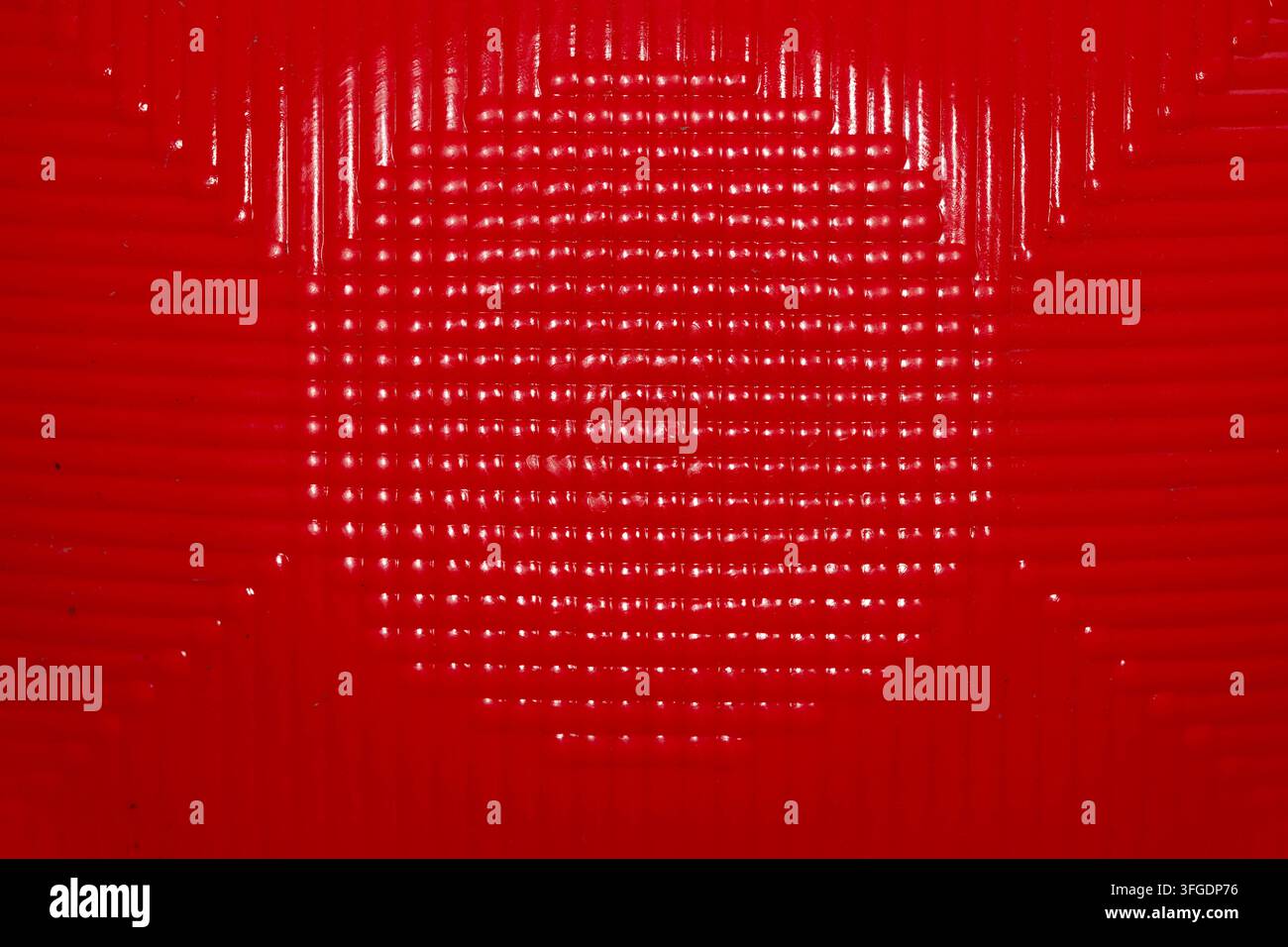 Abstrakte Makroaufnahme, die eine lebhafte rote geometrische Textur mit sich wiederholenden Linien und strukturiertem Muster zeigt. Nützlich als Hintergrund oder Designelement. Stockfoto
