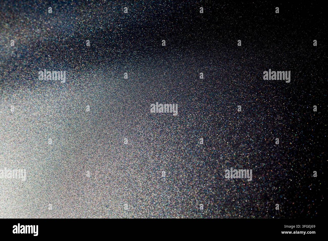 Abstrakte Makrotextur einer dunklen, metallisch glitzernden oder beschichteten Oberfläche mit feinen Granulierungen, die das Licht einfängt und einen sanften Farbverlauf und Schimmer erzeugt Stockfoto