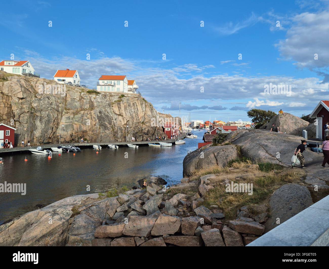 Felsige Küste und Küstenbauten auf der anderen Seite des Wassers nahe Smögen, Bohuslän an der Westküste Schwedens - Smartphone-aufgenommenes Stockfoto