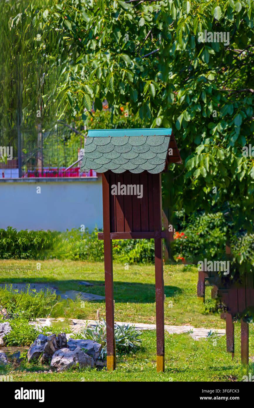Leere Holztafel mit Bäumen im Parkgarten im Freien Stockfoto