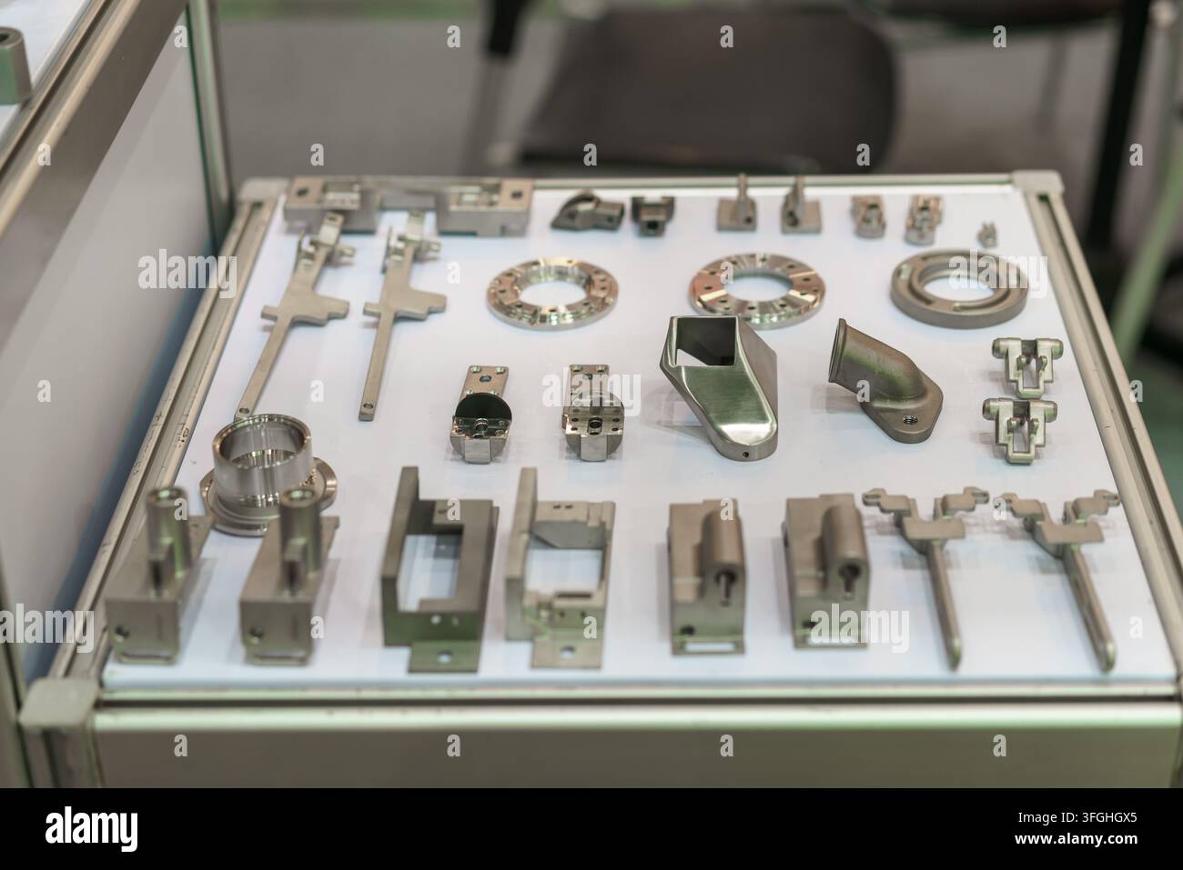 Eine Ausstellung verschiedener maßgefertigter Metallkomponenten, Halterungen und mechanischer Teile, die Präzisionsengineering und Fertigungsqualität demonstriert für Stockfoto