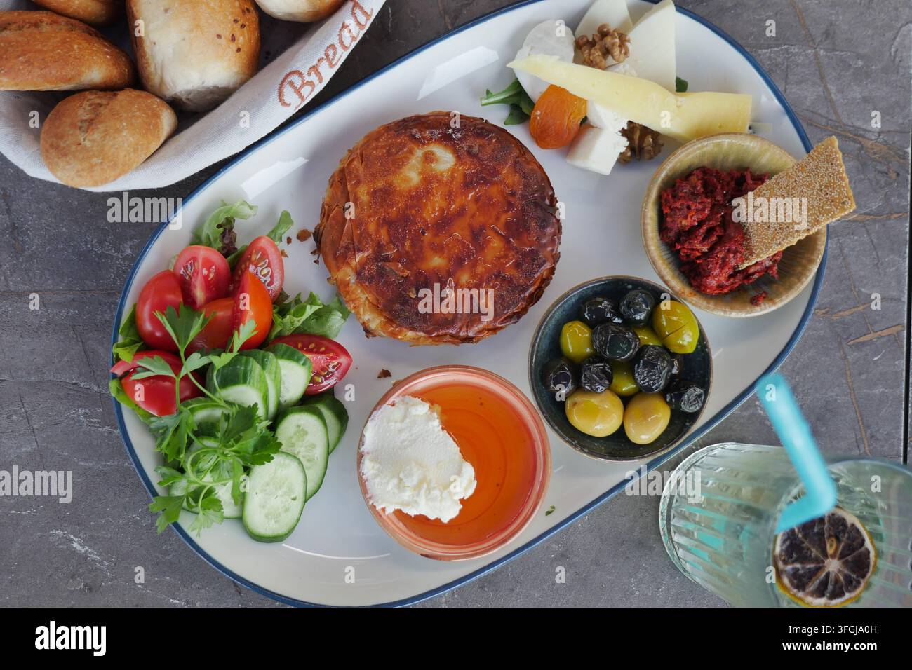 Mediterranes Mezze-Platte mit gebackenem Käse, Oliven, frischem Gemüse und Dips Stockfoto