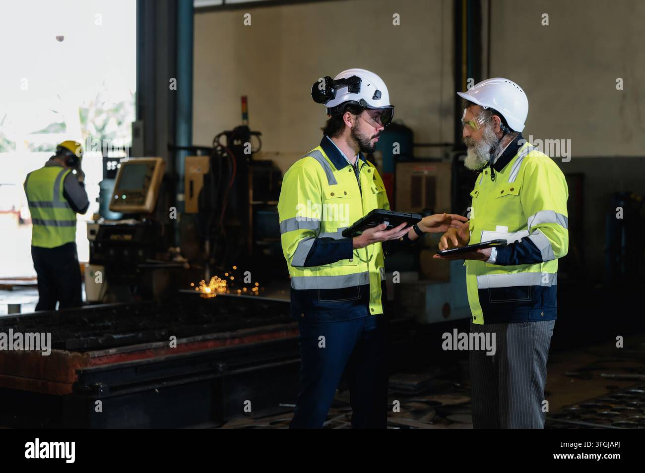 Industrietechniker diskutiert industrielle Arbeitsabläufe mit leitendem Ingenieur im Produktionswerk. Konzept der Unternehmensführung im Ingenieurwesen, Corporat Stockfoto