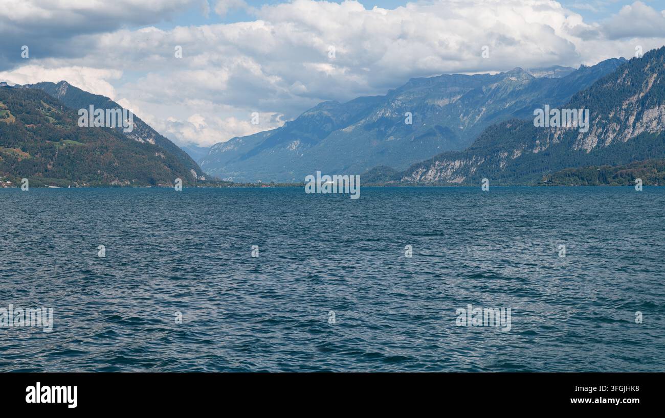 Panoramablick auf den Thunersee in Richtung Interlaken, eingerahmt von Alpen unter einer bewölkten Himmel in der Schweiz Stockfoto