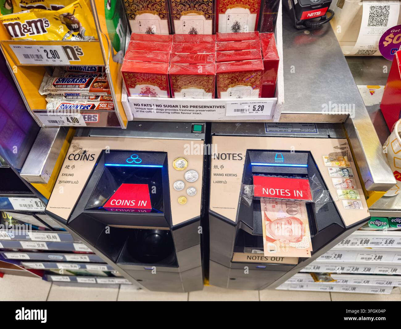 automatisiertes Kassensystem, das in eine Einzelhandelskasse integriert ist, Schlitze zum Annehmen und Ausgeben von Münzen und Geldscheinen, Singapur Stockfoto