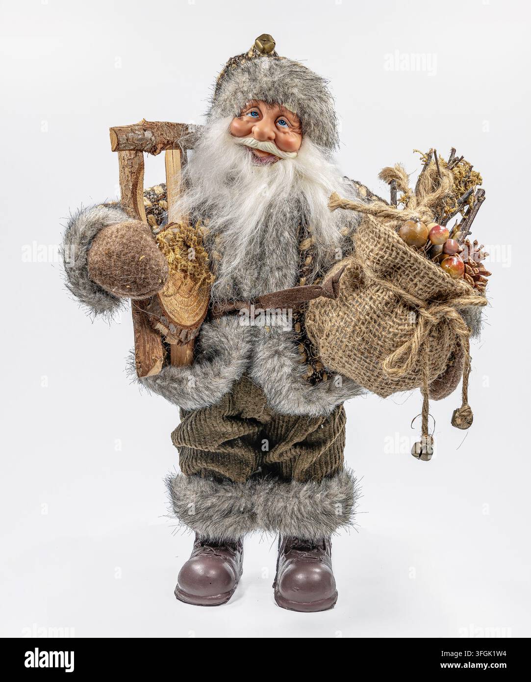 Traditionelle Nikolauspuppe mit Pelzbekleidung, Sack und rustikalen Accessoires, isoliert auf weißem Hintergrund, deutsche Weihnachtsdekoration. Stockfoto