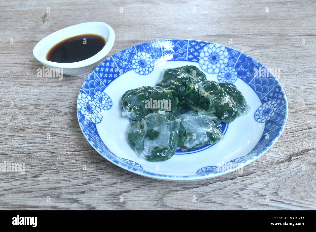 Backen von Guizhou-Dumpling mit gefüllter Knoblauchschote auf einem Teller, getaucht in scharfe schwarze Sojasauce Stockfoto