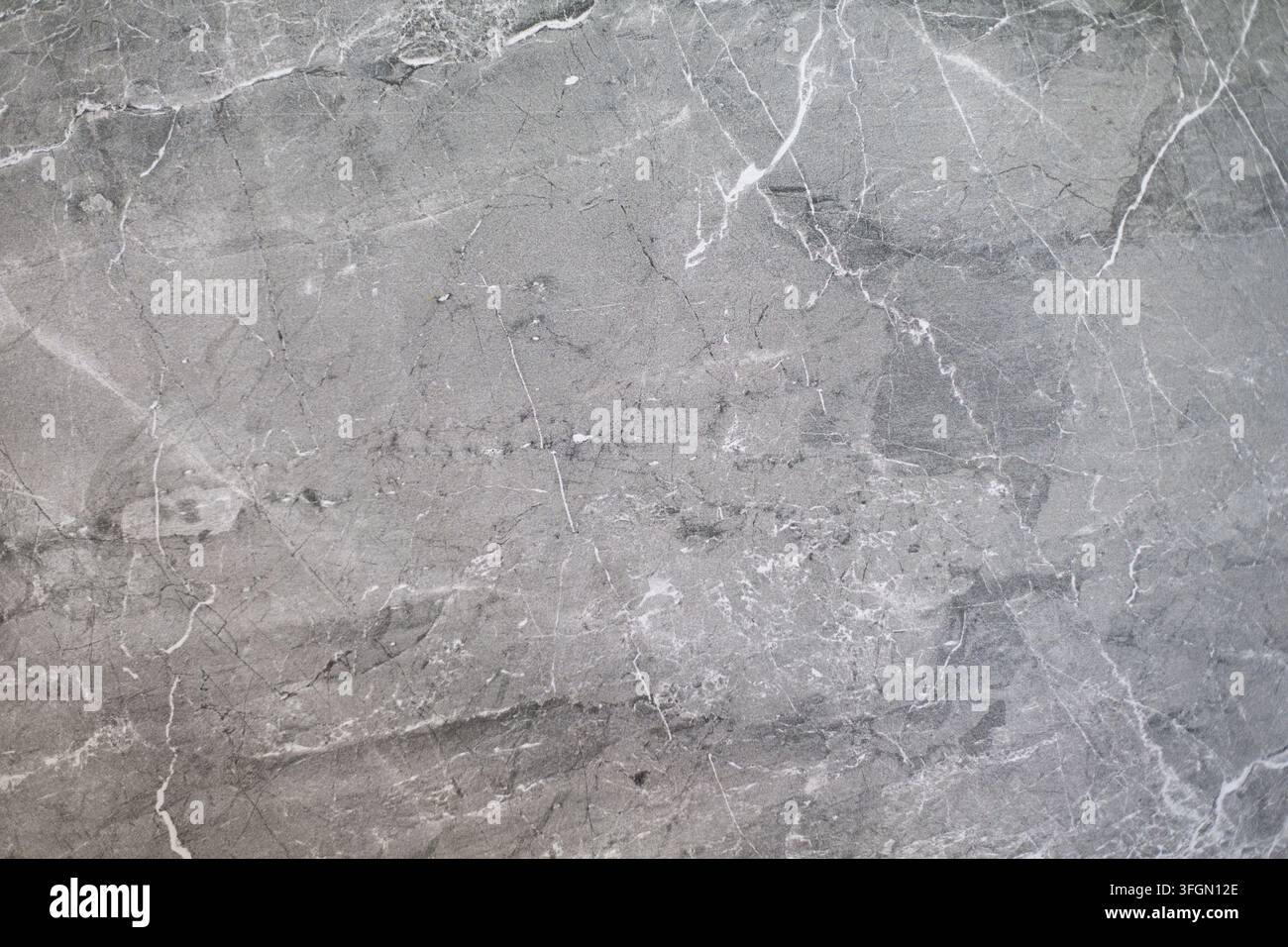 Graue Marmorsteintextur mit weißen Adern. Nahaufnahme von grauem Marmorstein mit feinen weißen Adern, Rissen und natürlicher Textur. Stockfoto