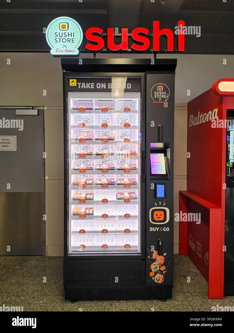 Sushi Store-Automat auf dem Warschauer Flughafen mit dem Text "Take on board" Stockfoto