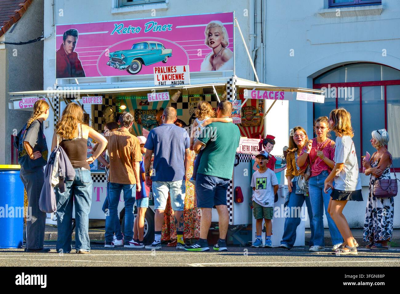 Menschen und Familien stehen vor einem Fast-Food-Truck an, um Erfrischungen auf einem Open-Air-Festival zu genießen – Ligueil, Indre-et-Loire (37), Frankreich. Stockfoto