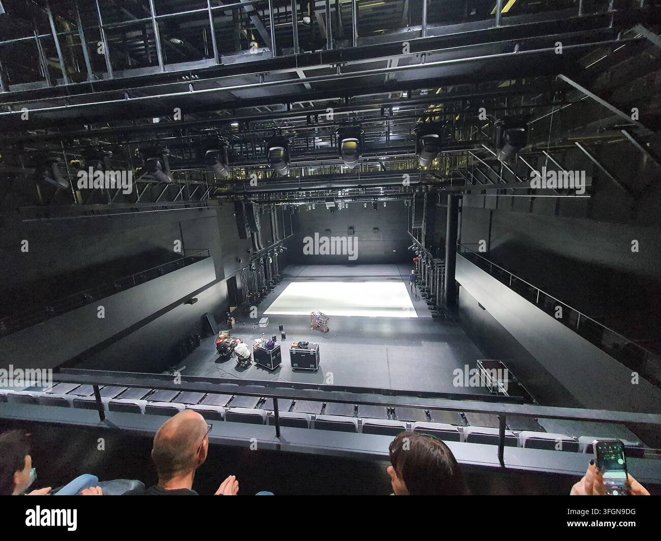 Innenansicht eines modernen Black-Box-Theaters oder experimentellen Veranstaltungsortes, fotografiert aus einer erhöhten Zuschauerperspektive. Das Bild fängt ein Stockfoto