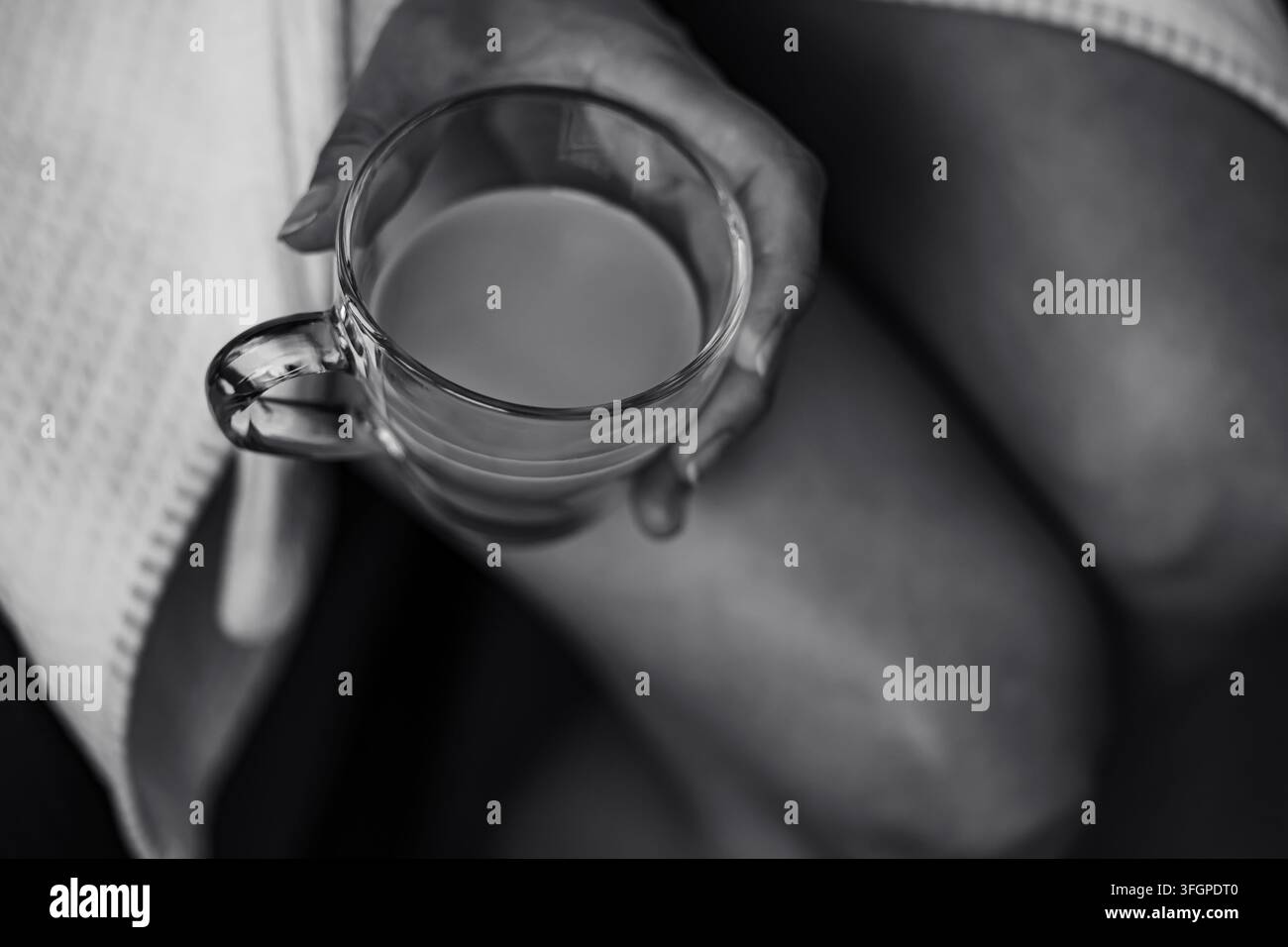 Ein ruhiger Morgenmoment mit einer warmen Tasse Kaffee in einem weichen weißen Bademantel Stockfoto