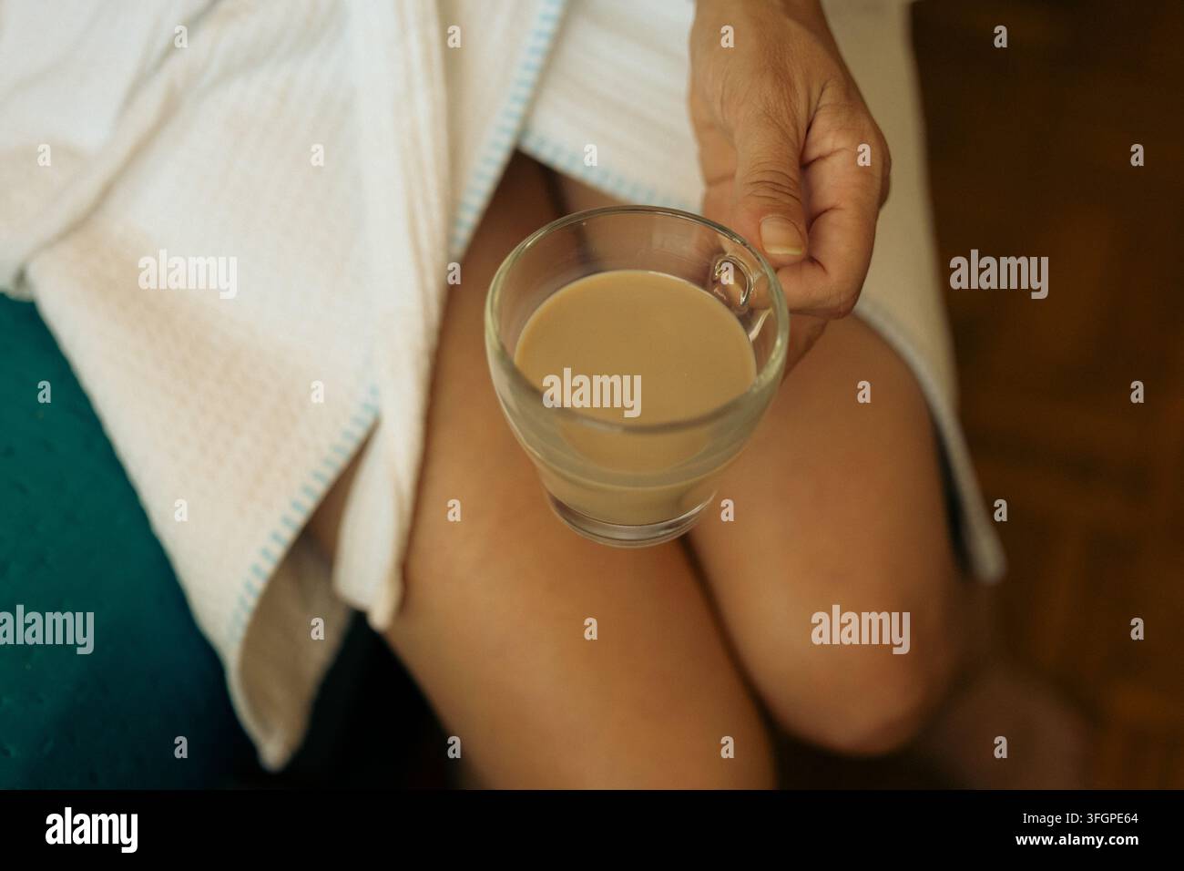 Ein ruhiger Morgenmoment mit einer warmen Tasse Kaffee in einem weichen weißen Bademantel Stockfoto