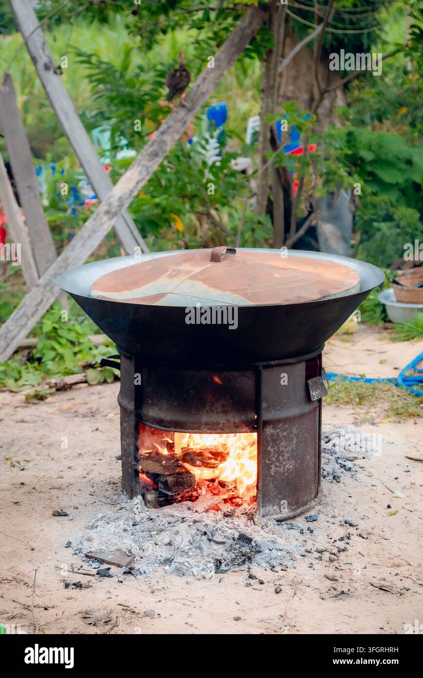 Traditioneller Holzofen-Kochtopf im Freien auf einem Metalltrommelherd Stockfoto