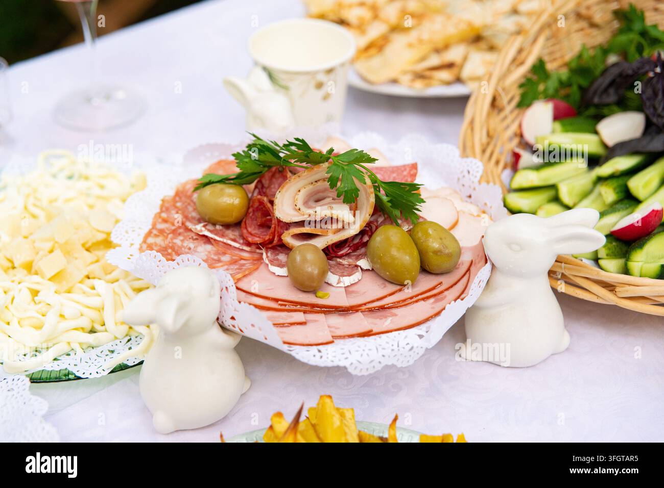 Ein dekoratives Serviertablett, arrangiert mit verschiedenen geschnittenen Cold Cuts, gerolltem Delikatessenfleisch, Salami und grünen Oliven. Frische Petersilie und geschnittenes Gemüse Stockfoto