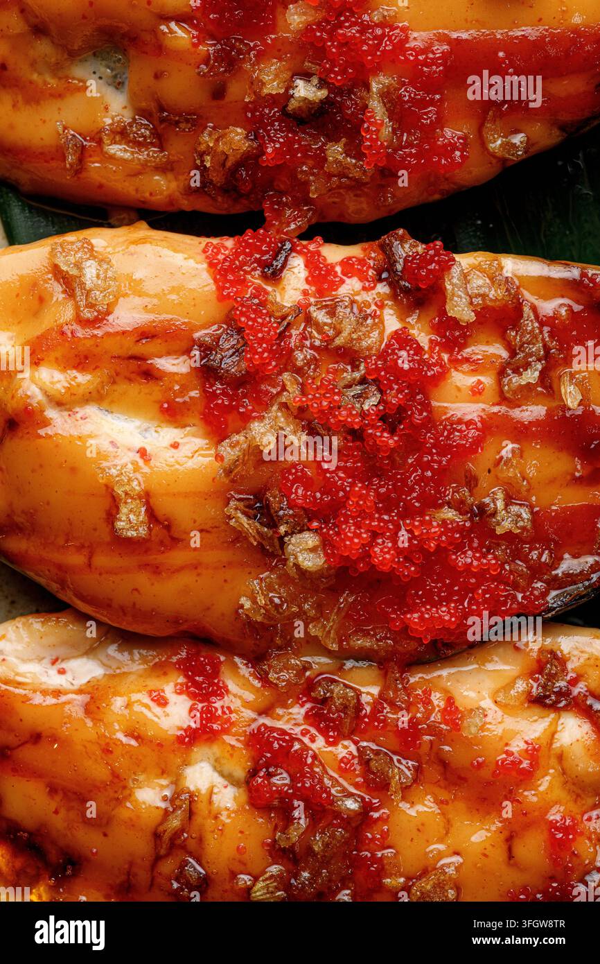 Gegrillte Muscheln mit Tobiko-Rogen und knusprigen Belägen Stockfoto